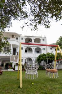 two swings in the grass in front of a building at Villa Duraku in Ulcinj