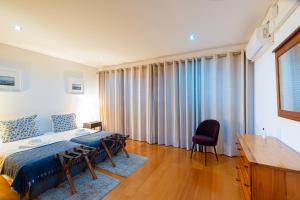 a bedroom with a bed and a table and chairs at Sailorman and Friends in Ponta Delgada
