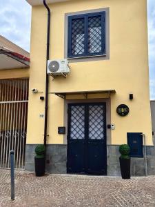 żółty budynek z niebieskimi drzwiami i oknem w obiekcie 80040GuestHouse w mieście Cercola