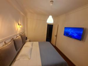 a small bedroom with a bed and a painting on the wall at Monteiro Duplex Terrace in Serradas