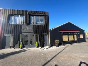 a person walking in front of a black building at Y Hostel in Amsterdam