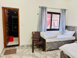 a bedroom with two beds and a chair and a window at Juyal palace in Jāmb +9 photos