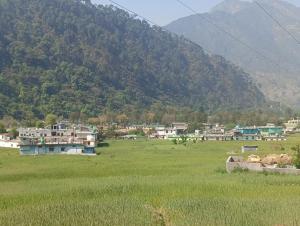 a town in a field with a mountain in the background at Juyal palace in Jāmb