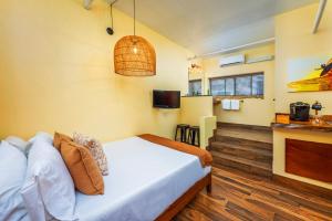 圣克莱门特Nomads Hotel的一间带床、壁炉和电视的卧室