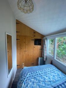 a bedroom with a blue bed and a window at Chalet 5 Clarach Bay in Aberystwyth