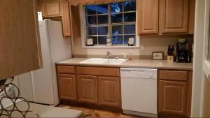 a kitchen with a sink and a white dishwasher at 4br Coastal Home I Sleeps 12 I Dock & Firepit in Gautier