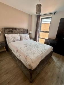 マンチェスターにあるCity Centre 2 bed apartment with a balconyの大きなベッドと大きな窓のある寝室
