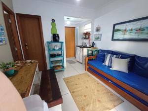 a living room with a blue couch and a table at BEIRA MAR APTO 711 in Ubatuba