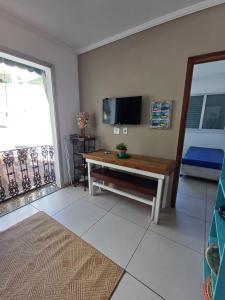 a living room with a table and a tv at BEIRA MAR APTO 711 in Ubatuba