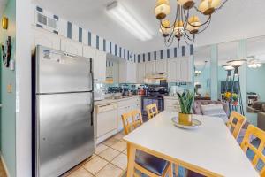 オレンジビーチにあるSeaside Beach & Racquet Club 2204の冷蔵庫と椅子付きのテーブルがあるキッチン