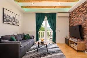 a living room with a couch and a tv at Divine Apartment Drnis - "Modern comfort at the gateway to Krka National Park" in Drniš