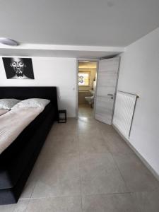 ローゼンハイムにあるStadt Apartments Badeのベッドルーム1室(ベッド1台付)、廊下(バスルーム付)