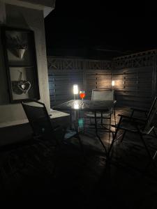 a room with a table and chairs at night at Helski Zakątek in Hel +3 photos