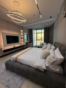 a large bedroom with a large bed and a flat screen tv at TOP VIEW Beachfront, luxurious homes with sea view in Ajman 