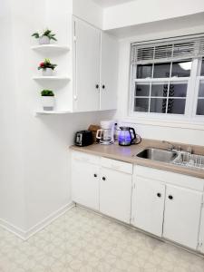 Una cocina con gabinetes blancos y un fregadero. en Excellence vacation home, en St. John's