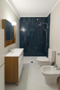 Un baño con dos lavabos, un inodoro y una ducha. en Fuseta Mel Rooftop Ocean view, en Fuseta