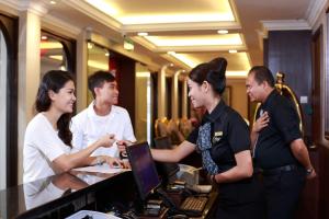 a group of people standing around a counter with a computer at Kimberley Hotel Georgetown in George Town