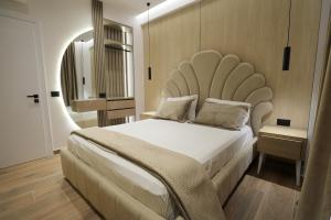 a bedroom with a large bed with a large headboard at Apartments Romario in Sarandë +218 photos