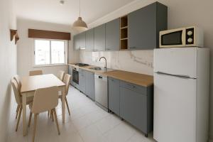 Una cocina con una mesa y un refrigerador blanco. en Fuseta Mel Rooftop Ocean view, en Fuseta 35 fotos más
