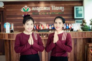 twee vrouwen die voor een toonbank staan te bidden bij Relax Hotel in Phnom Penh