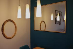 a mirror and lights in a room with a table at Il Glicine in Livorno