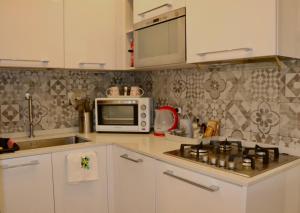a kitchen with a microwave and a stove top oven at Il Glicine in Livorno +7 photos
