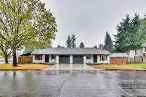 a house with a driveway in the rain at Lovely Vancouver Retreat with Home Gym! in Vancouver