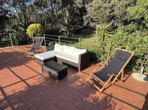 un patio de ladrillo con sofá y sillas. en 2 Tuscan seafront apartments with private access to sea, en Castiglioncello