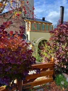 un banco de madera frente a un edificio con flores en Casa Suiza, vistas panorámicas al lago, ciudad y montañas !!, en San Carlos de Bariloche