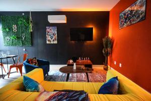 a living room with a yellow couch and a table at Chill in Style Anime Themed Escape in Philadelphia