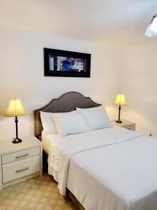 1 dormitorio con 2 camas y 2 lámparas en Excellence vacation home, en St. John's