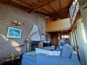 Una sala de estar con un sofá azul y una chimenea. en Casa Suiza, vistas panorámicas al lago, ciudad y montañas !!, en San Carlos de Bariloche
