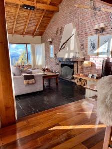 Una sala de estar con un sofá y una chimenea. en Casa Suiza, vistas panorámicas al lago, ciudad y montañas !!, en San Carlos de Bariloche