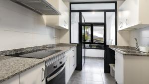 a kitchen with white cabinets and granite counter tops at Casa Amy-Costa Teguise in Costa Teguise +10 photos