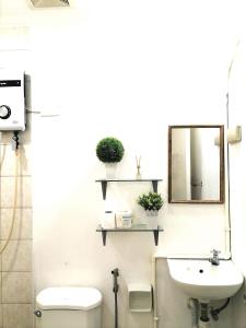 a bathroom with a toilet and a mirror and a sink at Mr B Guest House Room Rentals in San Fernando, Cebu in San Fernando +12 photos