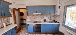 eine Küche mit blauen Schränken und einer Spüle in der Unterkunft La Tenería Chalet in El Tiemblo