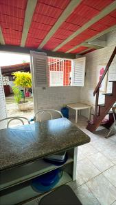 塔曼达雷Casa Totonho praia dos Carneiros的厨房配有柜台和桌椅 更多9张照片