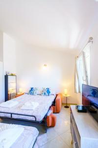 a bedroom with two beds and a flat screen tv at Cá Stella studio Flat in Riomaggiore