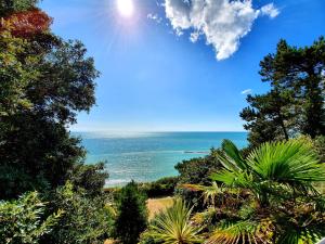 a view of the ocean from a hill with trees at Dine with the Sunset - Central Folkestone Gem in Folkestone