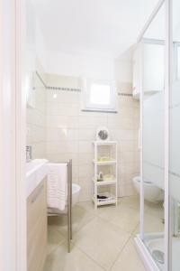 a white bathroom with a sink and a toilet at Cá Stella studio Flat in Riomaggiore +19 photos