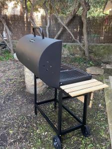 a bbq grill with a wooden bench next to it at Belvedere apartment in Castiglione della Pescaia