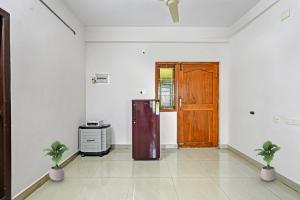 Habitación vacía con nevera y puerta de madera. en Hotel O Coastal Inn Luxury Service Apartments, en Kākināda