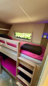 a bedroom with two bunk beds and a window at Caravana Juliana Hobby 545 z widokiem na Jezioro in Swaderki