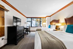 a hotel room with two beds and a television at Everline Resort & Spa Palisades- Forest View no resort fee in Olympic Valley