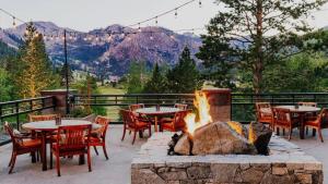 a patio with tables and chairs and a fire pit at Everline Resort & Spa Palisades- Forest View no resort fee in Olympic Valley