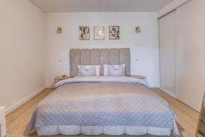 a bedroom with a large bed with a gray headboard at Coteaux en Vue Duo in Aureville