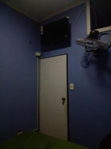 una camera con una parete blu e una porta bianca di Hostal Palmera a Rancagua