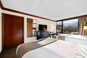 una camera d'albergo con due letti e una grande finestra di Everline Resort & Spa Palisades- Valley View a Olympic Valley