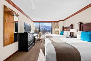 una camera d'albergo con due letti e una grande finestra di Everline Resort & Spa Palisades- Valley View a Olympic Valley