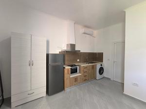a kitchen with a black refrigerator and wooden cabinets at KAFUL APARTMENTS in Qeparo